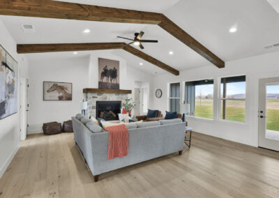 Living room with vaulted ceilings and windows with wood beams